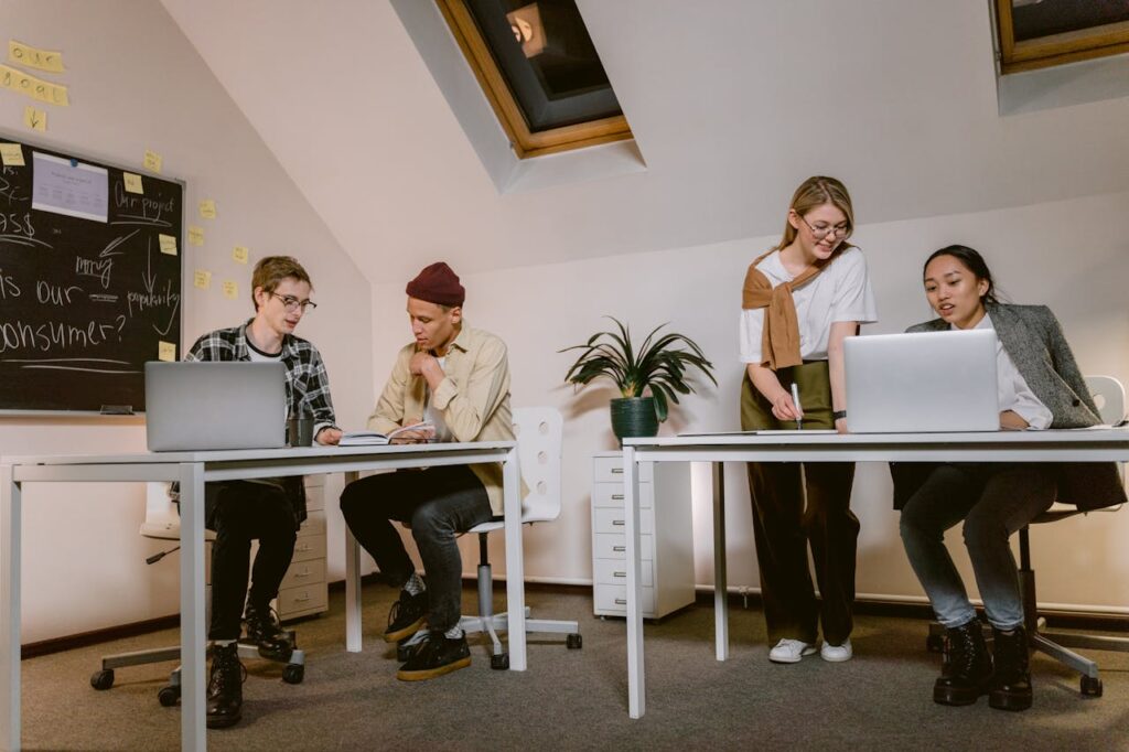 Young professionals brainstorm and work together at a modern office desk.
